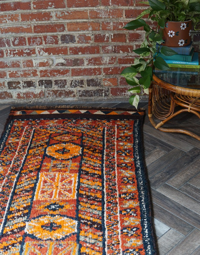 11 foot by 3 foot Turkish high pile Herki runner, featuring a black, red and orange geometric pattern throughout