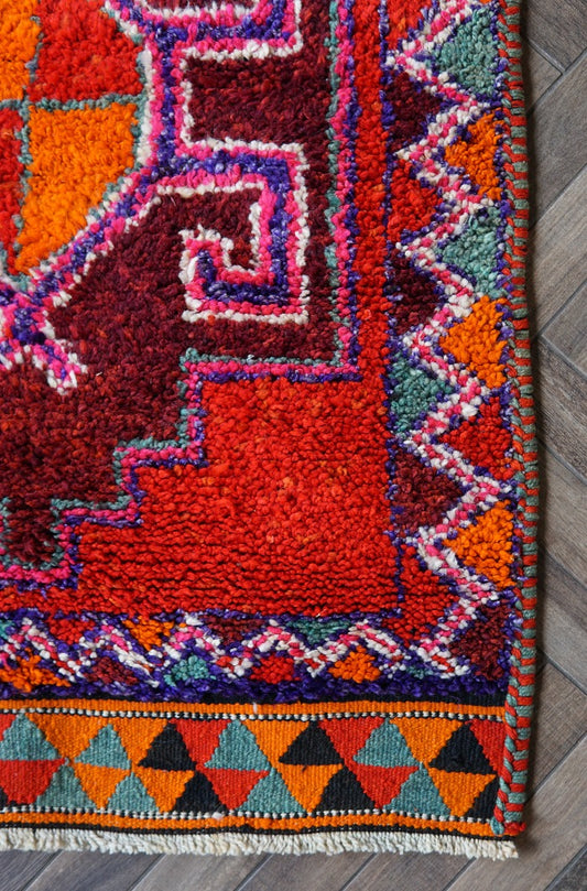 10.8 by 3.3 foot high pile turkish runner featuring bright pops of red and orange and three large medallions. Southwestern feel and style with a beautiful diamond pattern around the border