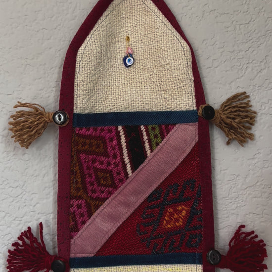 multi-colored three pocket wall organizer made from scraps of colorful Turkish kilim rugs with yarn tassels at each end