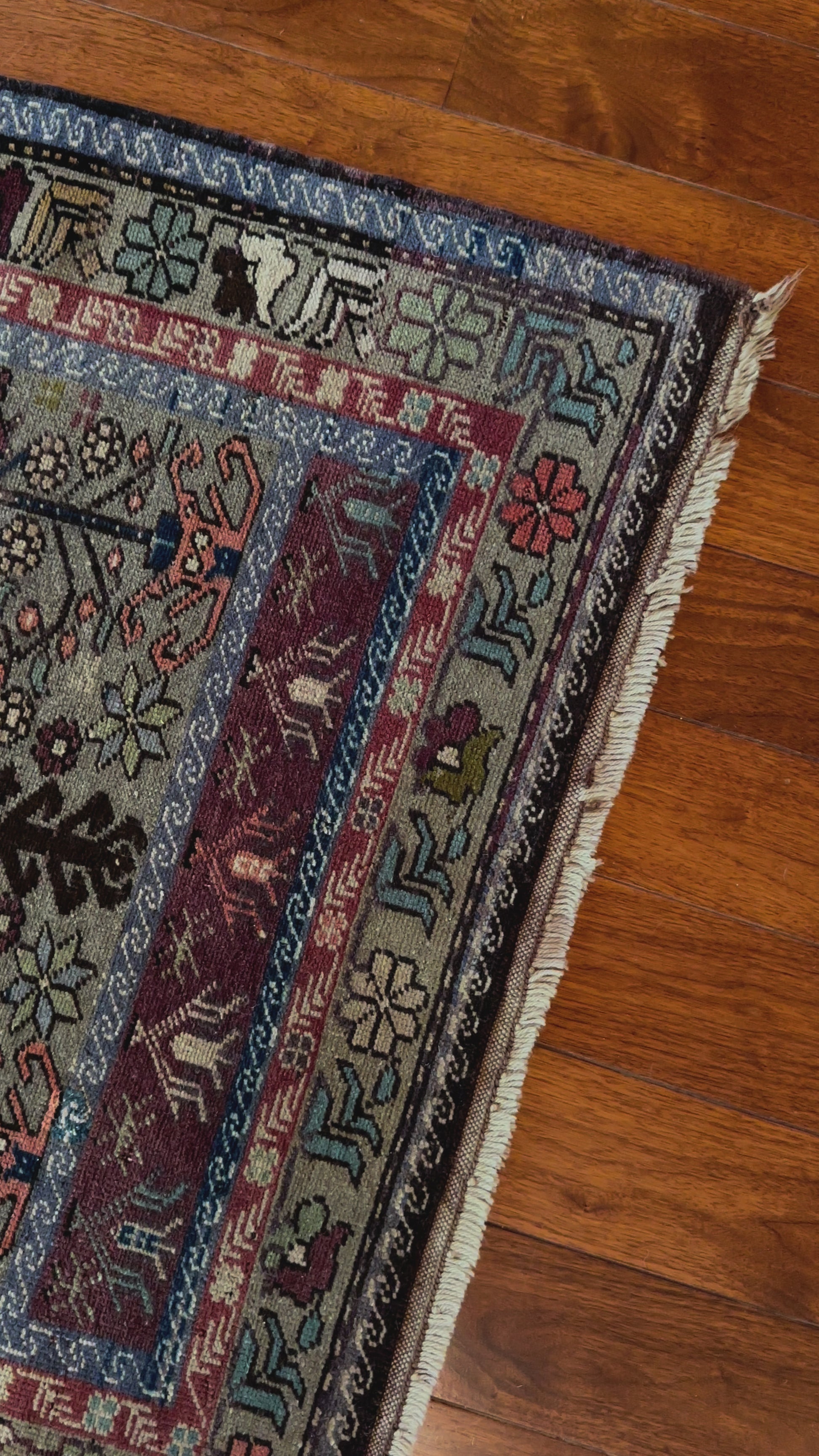 Large vintage Turkish rug featuring floral and geometric designs with hues of navy, robin eggs blue, olive, mauve and taupe.