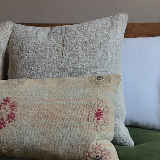 12 by 36 neutral lumbar pillow featuring light yellow and blue plaid and colorful floral embroidery throughout