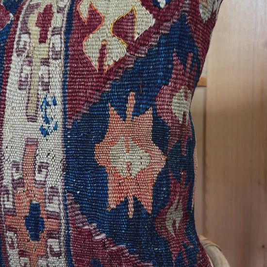 Handwoven red and green Turkish throw pillow, 16x16 inches, wool front with geometric design and pops of light blue and maroon, cotton backing—boho home decor.