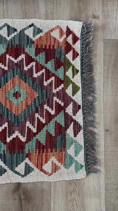 mini colorful Turkish rug featuring pops of red, orange green and blue and geometric diamond pattern throughout