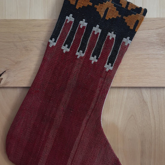 handmade Turkish Christmas stocking featuring a solid red body and a black and orange geometric top