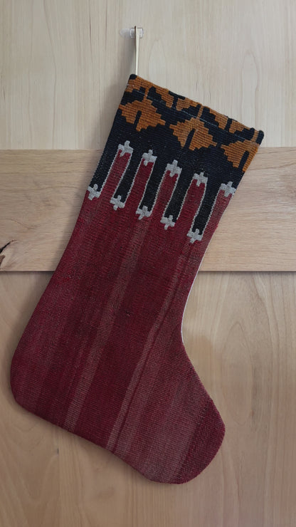 handmade Turkish Christmas stocking featuring a solid red body and a black and orange geometric top