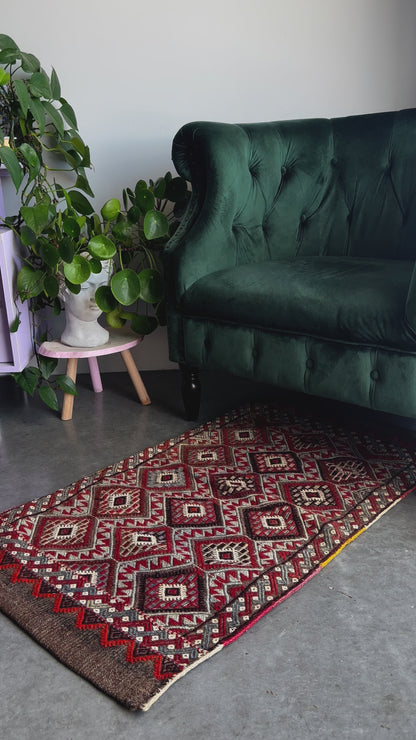 Mini Turkish Rug featuring pops of red and light blue with a repeating diamond pattern throughout