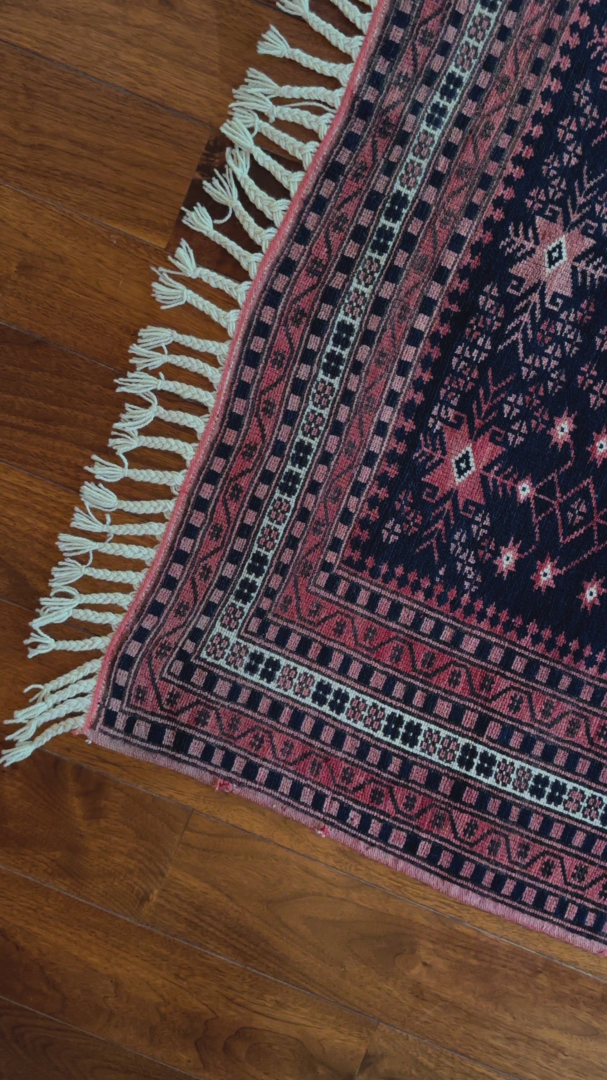 Handmade Turkish rug featuring navy and raspberry hues and 7 different borders with floral and geometric designs