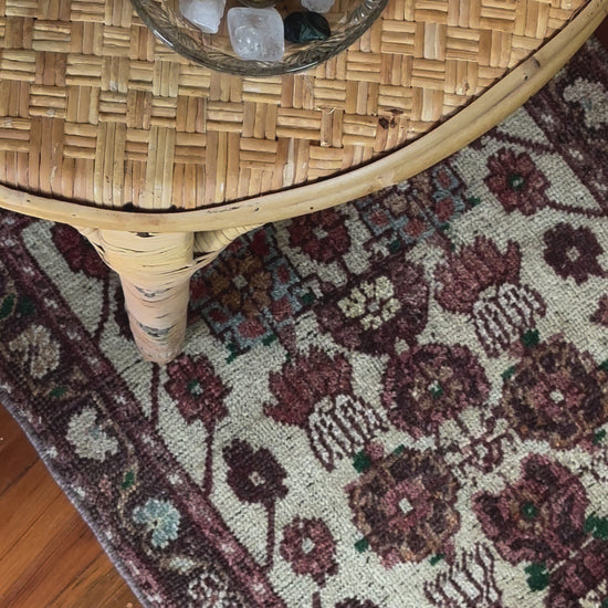 Vintage Turkish wool rug with a floral tree of life design in burgundy, green, and ivory tones, featuring a detailed border of small floral motifs.