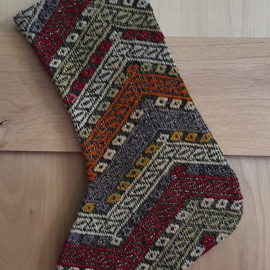 colorful striped turkish christmas stocking featuring red, green, orange and blue embroidered geometric lines