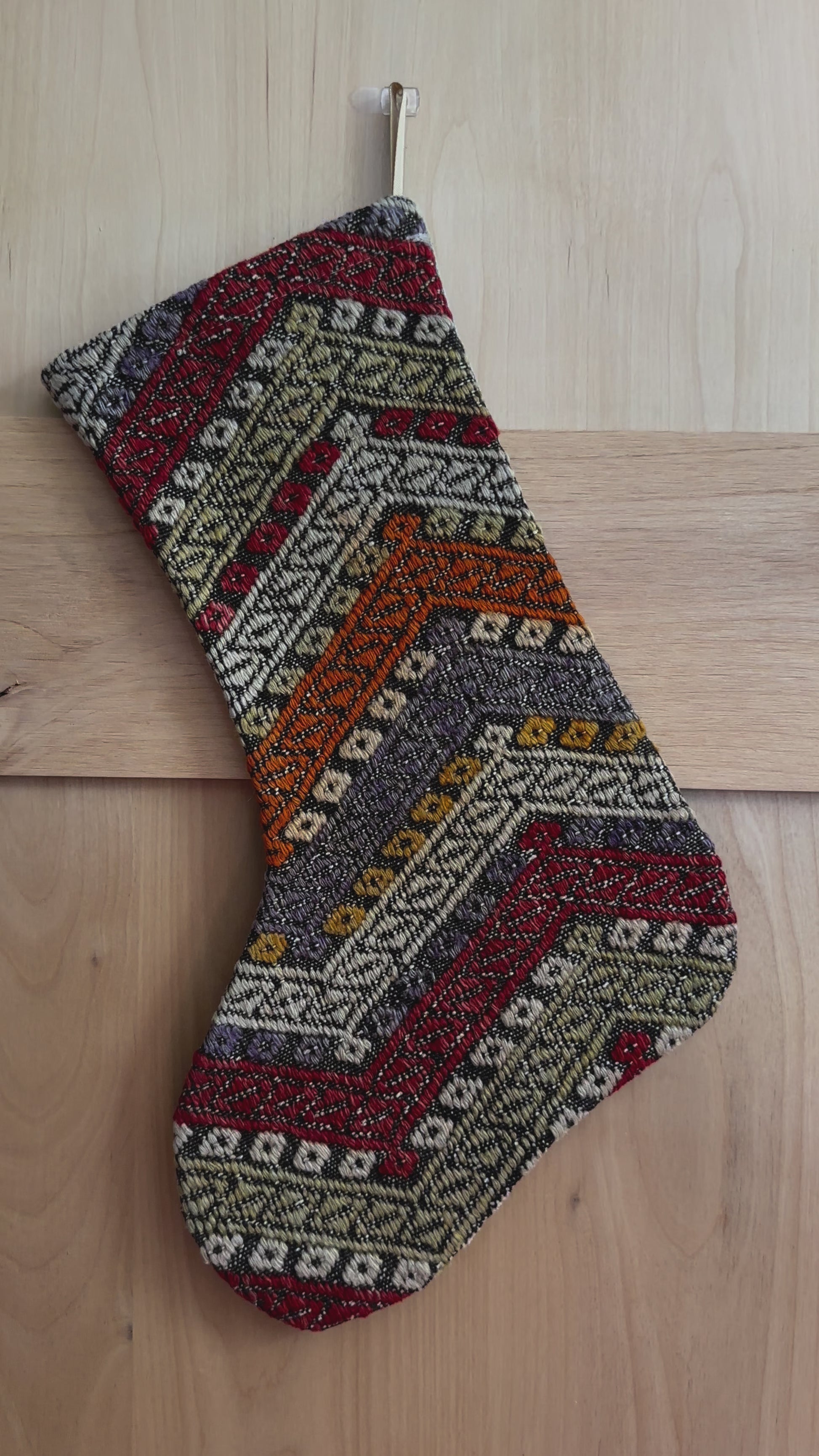 colorful striped turkish christmas stocking featuring red, green, orange and blue embroidered geometric lines