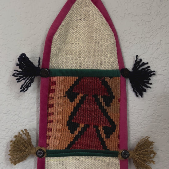 multi-colored three pocket wall organizer made from scraps of colorful Turkish kilim rugs with yarn tassels at each end