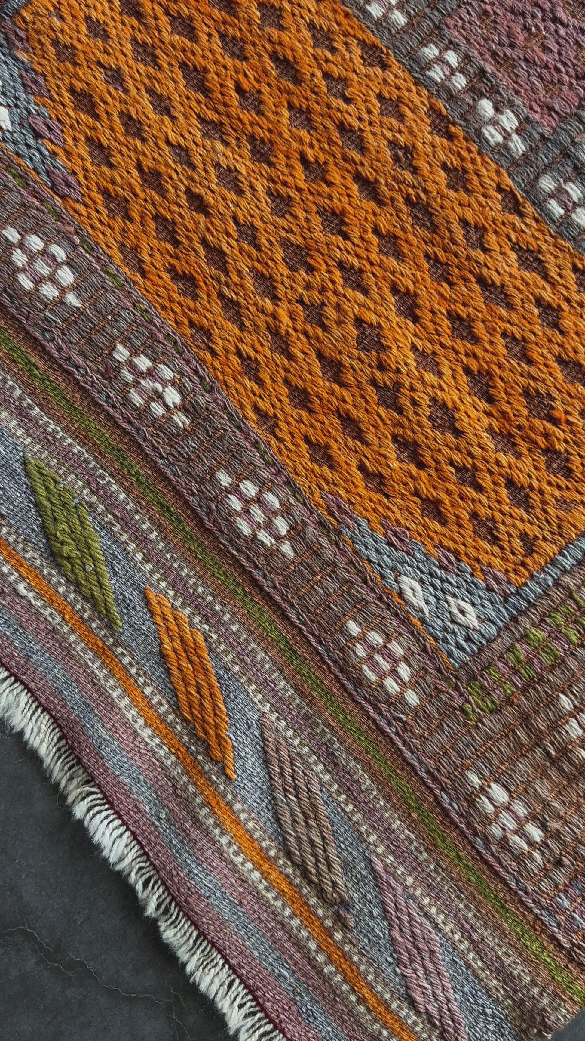 4.5 by 3 colorful turkish area rug featuring bright pops of orange and muted neutrals and pops of blue and green