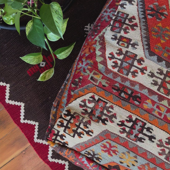 Handmade vintage Turkish rug pouf with red and orange tones, up-cycled from authentic wool Kilim rugs. Perfect as a unique bohemian floor cushion, ottoman, or accent seating for living rooms, bedrooms, or cozy spaces. Ethically crafted by artisans in Turkey.