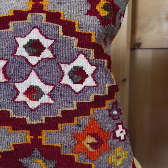 Handwoven purple Turkish throw pillow, 16x16 inches, wool front with geometric star design and pops of orange and red, cotton backing—boho home decor.